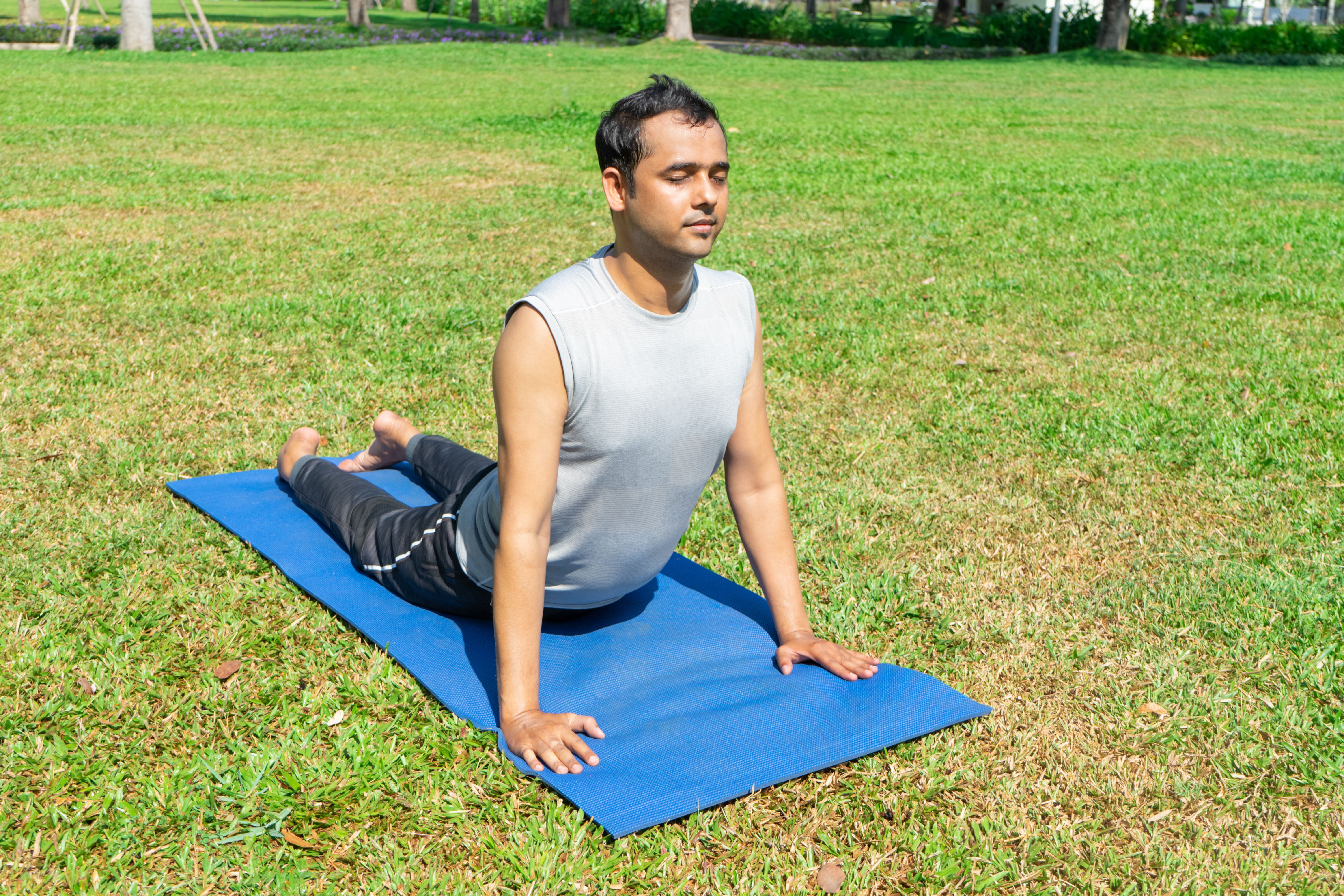 indian-man-doing-upward-facing-dog-pose-outdoors-green-lawn-outdoor-yoga-concept.jpg